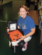 Ellen Barkin holds the AED that saved the life of a senior basketball player, May 29, 2007 Garrett Richter