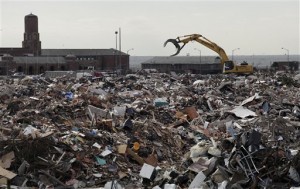 A piece of construction equipment works on the pile of debris, collected during the cleanup from Superstorm Sandy, in the parking lot of Jacob Riis Park in the Rockaway section of the Queens borough of New York, Wednesday, Nov. 14, 2012. Sandy devastated shoreline communities in New York Oct. 29. (AP Photo/Mark Lennihan)