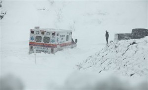 An ambulance is stuck in over a foot of snow off of Highway 33 West, near Belington, W.Va. on Tuesday, Oct. 30, 2012, in Belington, W.Va. Superstorm Sandy buried parts of West Virginia under more than a foot of snow on Tuesday, cutting power to at least 264,000 customers and closing dozens of roads. At least one death was reported. The storm not only hit higher elevations hard as predicted, communities in lower elevations got much more than the dusting of snow forecasters had first thought from a dangerous system that also brought significant rainfall, high wind gusts and small-stream flooding. (AP Photo/Robert Ray)