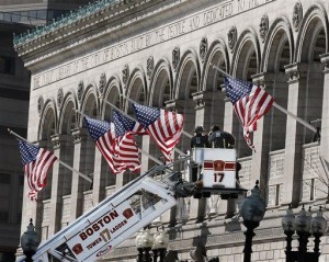 Responders search the area around the Boston Public Library near the finish line of the Boston Marathon with a ladder truck in Boston Tuesday, April 16, 2013. Two bombs blew up seconds apart Monday at the finish line of one of the world's most storied races, tearing off limbs and leaving the streets spattered with blood and strewn with broken glass. At least three people were killed, including an 8-year-old boy, and more than 170 were wounded. (AP Photo/Winslow Townson)