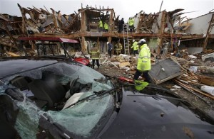 A smashed car sits in front of an apartment complex destroyed by an explosion at a fertilizer plant in West, Texas, as firefighters conduct a search and rescue Thursday, April 18, 2013. A massive explosion at the West Fertilizer Co. Wednesday night killed as many as 15 people and injured more than 160, officials said overnight. (AP Photo/LM Otero)