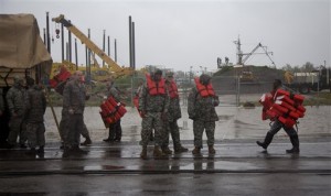 Guardsmen distribute life vests near Braithwaite, La., as they prepare to help flood victims from Plaquemines Parish, a rural area outside New Orleans that was flooded during Hurricane Isaac on Wednesday, Aug. 29, 2012. (AP Photo/Erik Schelzig)